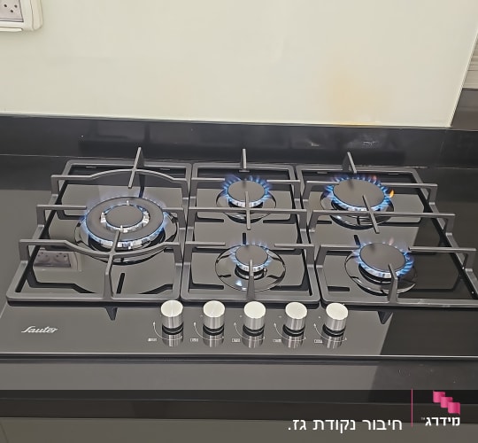 כיריים גז עם להבות כחולות במטבח מודרני